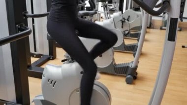 Güzel esmer bir kadının spor salonunda spor yaparken çekilmiş görüntüleri.