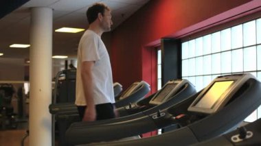 Spor salonunda ağırlık kaldıran yakışıklı bir genç.