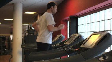 Spor salonunda ağırlık kaldıran yakışıklı bir genç.
