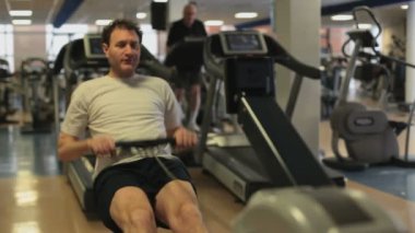 Spor salonunda ağırlık kaldıran yakışıklı bir genç.