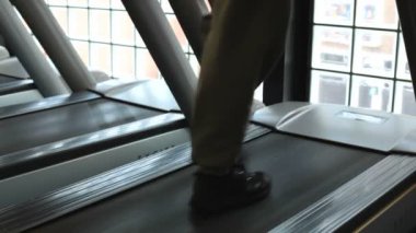 Spor salonundaki koşu bandında koşan sporcunun görüntülerini kapatın.