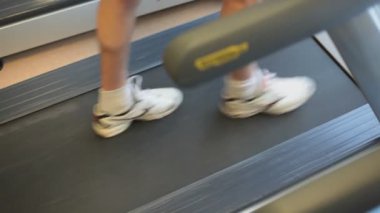 Spor salonundaki koşu bandında koşan sporcunun görüntülerini kapatın.