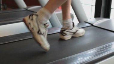 Spor salonundaki koşu bandında koşan sporcunun görüntülerini kapatın.
