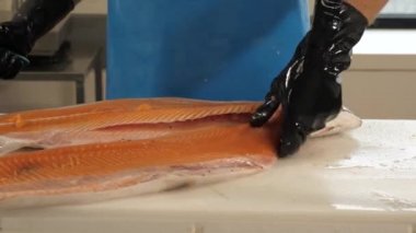 Endüstriyel restoran mutfağında somon balığı temizliyorum.
