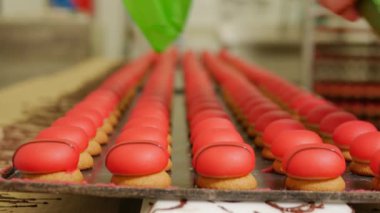 Pasta fabrikası çalışanlarının konveyör üzerinde şeker yaparken çekilmiş yakın çekim görüntüleri.