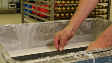 Pasta fabrikası çalışanlarının konveyör üzerinde şeker yaparken çekilmiş yakın çekim görüntüleri.