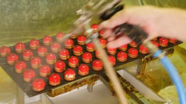 Pasta fabrikası çalışanlarının konveyör üzerinde şeker yaparken çekilmiş yakın çekim görüntüleri.