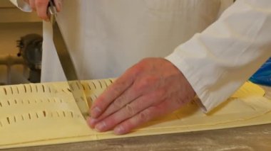 Pasta fabrikası çalışanlarının konveyör üzerinde şeker yaparken çekilmiş yakın çekim görüntüleri.