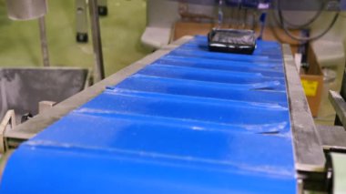 Fabrikadaki tatlı hamur işi paketleriyle nakliyecinin yakın çekim görüntüleri.