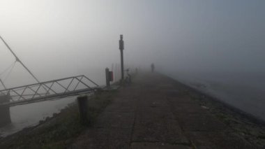 Puslu bir sabahki limanın manzaralı görüntüleri.