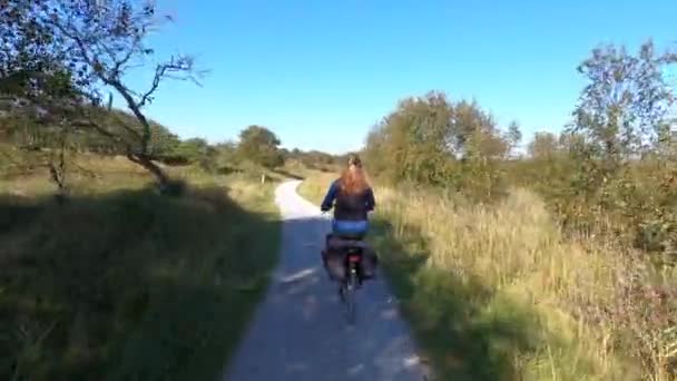Nainen Pyöräilee Schiermonnikoogin Dyynien Läpi Alankomaissa — kuvapankkivideo