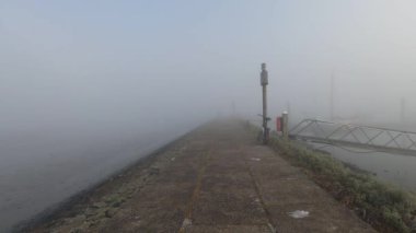 Puslu bir sabahki limanın manzaralı görüntüleri.