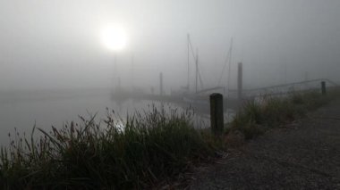 Puslu bir sabahki limanın manzaralı görüntüleri.