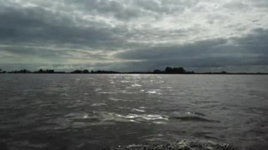 bulutlu bir günde nehirde yelkenli sürerken çekilen görüntüler