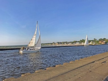 South Haven, Michigan, ABD 8 Haziran 2018: Iki Yelkenli Güney Haven, Michigan, ABD mavi gökyüzü kopya alanı ile liman doğru Michigan Gölü 'nden siyah nehir kadar seyahat.