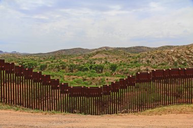 Border Fence beside a road near Nogales, Arizona separating the United States from Mexico. clipart