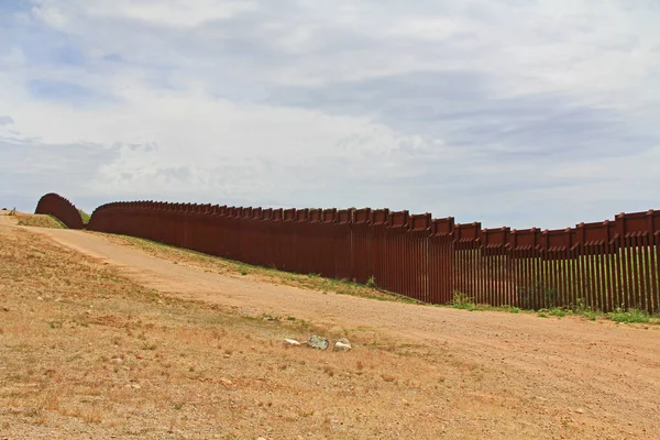 Border Fence beside a road near Nogales, Arizona separating the United States from Mexico.