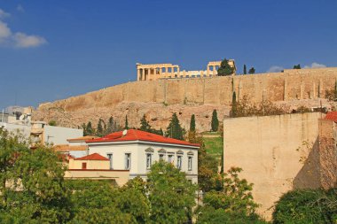 Atina, Attica, Yunanistan 17 Ekim 2018: Atina, Yunanistan Akropolü destek duvar güzel mavi gökyüzü kopya alanı ve yakın bir kaç evleri ile yukarıda Parthenon, ararken. 