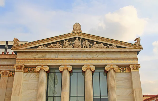 Right wing building, of the National Academy of Arts in Athens, Greece with ornate details and Greek statue carvings with blue sky copy space.