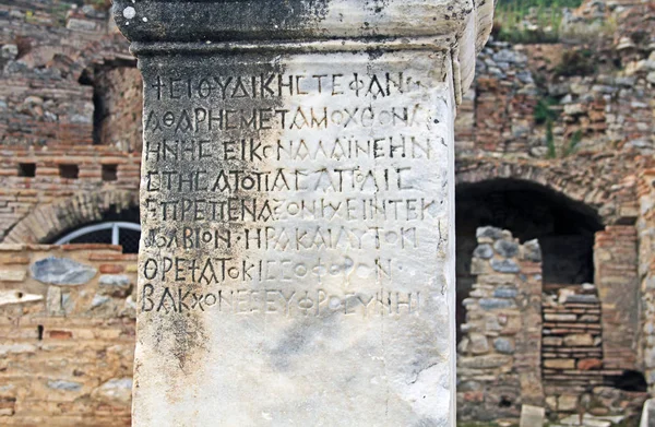 Ancient text on a marble pillar along the Curetes Road in the historic city ruins of Ephesus, Turkey near Selcuk.