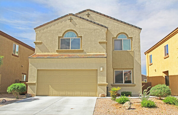 Новый двухэтажный дом в Тусоне, Аризона, США, с красивым голубым небом и ландшафтным дизайном
.