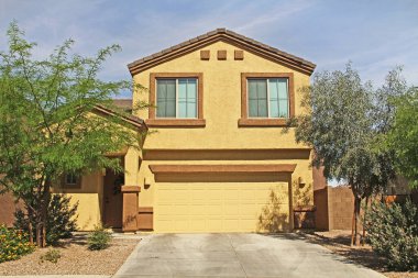 Tucson, Arizona, ABD - 7 Nisan 2017: Yeni iki katlı, kahverengi ve sarı sıva ev Tucson, Arizona, ABD Güzel mavi gökyüzü ve peyzaj.