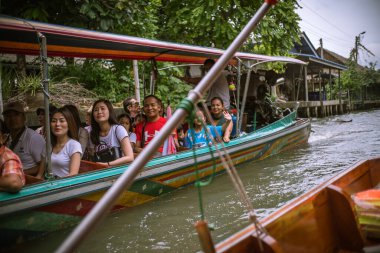 Uzun kuyruklu bir teknede turistler