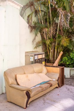 Dışardaki çöpe atılmış eski bir döşek ve yanında bir avuç avuçla.