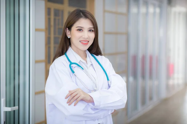 一位亚洲女医生拥抱着她的胸部 穿着白袍和听诊器 — 图库照片