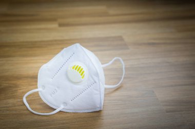 Hava kirliliğini korumak için tıbbi maske 2.5 ve ahşap zemin üzerinde Coronavirus 19.