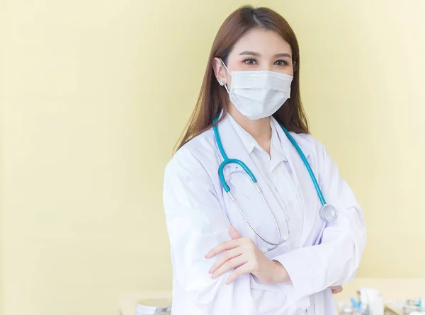 一位亚洲女医生手挽手站在那里 穿着白色长袍 戴着口罩和听诊器 Coronavirus保护概念 — 图库照片