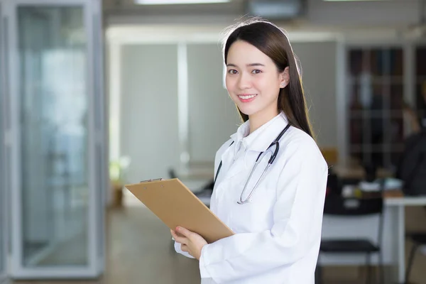 Asiática Mulher Médico Está Sorrindo Com Confiança Enquanto Ela Segura — Fotografia de Stock