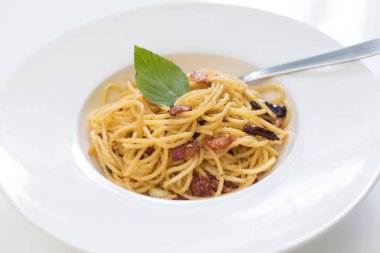 Kızarmış spagettiyi kurutulmuş biberli ve kızarmış pastırmayla karıştırın..