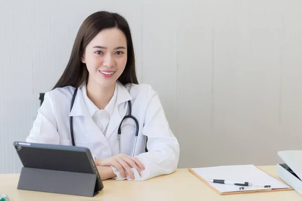 Asiática Hermosa Joven Sonriente Médico Femenino Sentado Consultorio Hospital Mesa — Foto de Stock