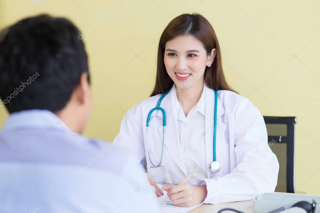 Una hermosa doctora asiática sonrió y preguntó sobre los síntomas