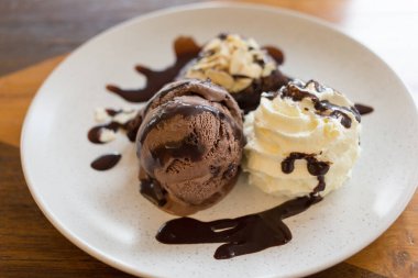 Çikolatalı İtalyan Dondurması Brownie ve Krem şantili Beyaz bir tabakta çikolata.