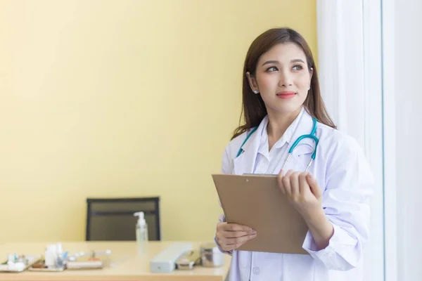 Eine Schöne Asiatische Ärztin Lächelt Hält Ein Klemmbrett Und Schaut — Stockfoto