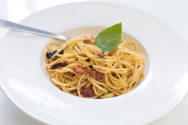 Kızarmış spagettiyi kurutulmuş biberli ve kızarmış pastırmayla karıştırın..