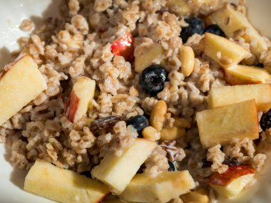 Yulaf ezmesi, fındık, tereyağı, süt ve taze meyve