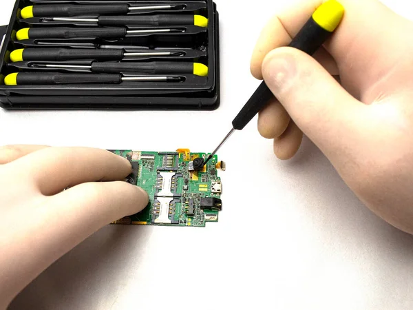 Mobile phone repair with tester and screwdriver