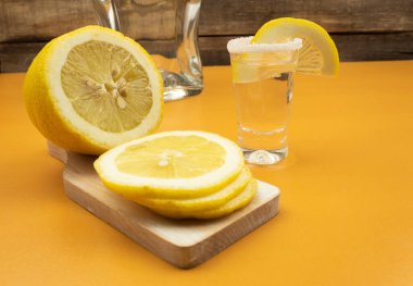 Ahşap arkaplanda limon ve tuzlu tekila.