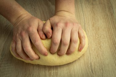 Kadın ekmek, ekmek ve zencefilli ekmek pişirmek için hamur yoğurur.