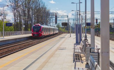 İstasyon platformunda elektrikli tren. Tren istasyona yaklaşıyor.