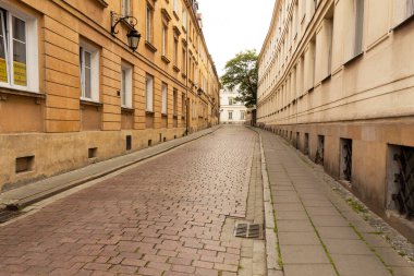 Varşova, Polonya - 16 Mayıs 2020: Kombine cadde ve eski şehirde evler. Şehir merkezinde parmaklıkları olan eski bir sokak.