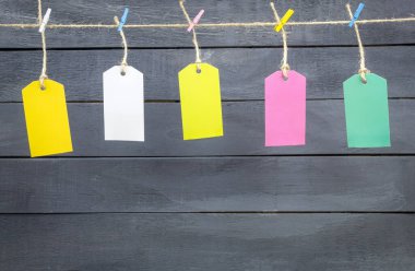 Renkli mandallar ve etiketler bir ipe asılmış.