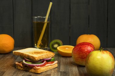 Kahvaltıda meyve suyu ve meyve suyu ile sandviç. Meyve suyu ve meyve suyu olan öğrenci için sağlıklı bir öğle yemeği. Teneffüste atıştırmalık.