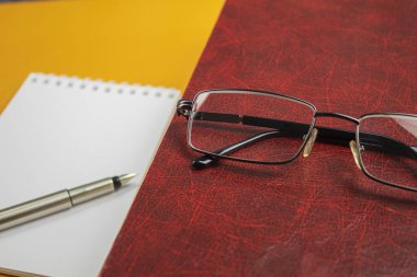 Masada gözlüklü bir kitap. Sevgili, gözlüklü kırmızı kitap ve mürekkep kalemi. Tasarımcılar için şablon