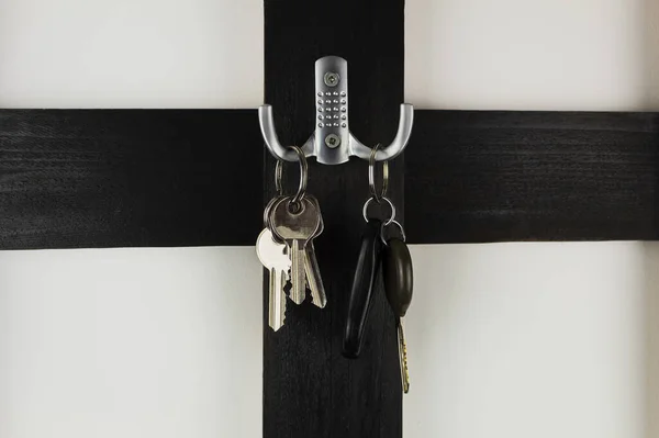 Keys on a hanger from a car and apartment. Keys hang on a wooden, black hanger