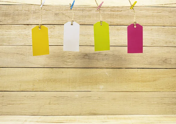 Ahşap bir arka planda ipe bağlanmış yazı için etiketler. Etiketler küçük mandallarda tutulur. Metin için çerçeve