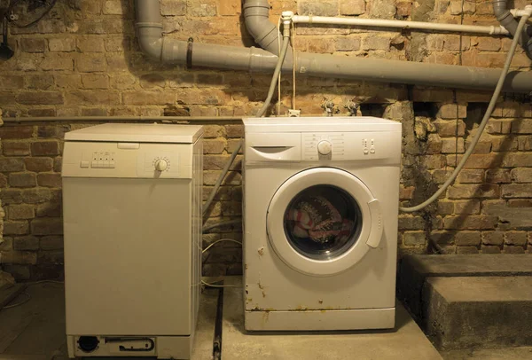 地下の古い洗濯機 下水道管を背景に古い洗濯機 — ストック写真